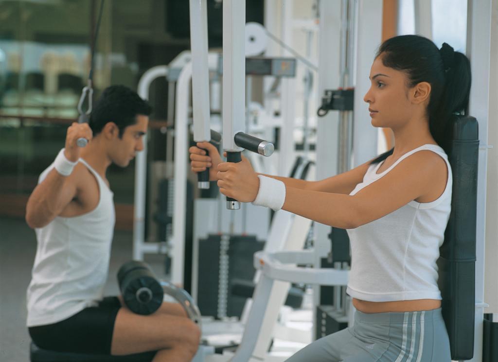 The Oberoi Bengaluru Hotel Екстериор снимка A woman using a lat pulldown machine